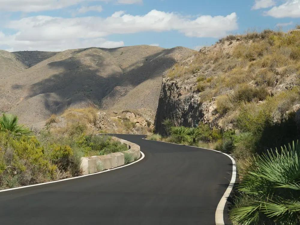 Discover the beauty of a winding road through the rugged, arid mountains, perfect for adventure seekers.