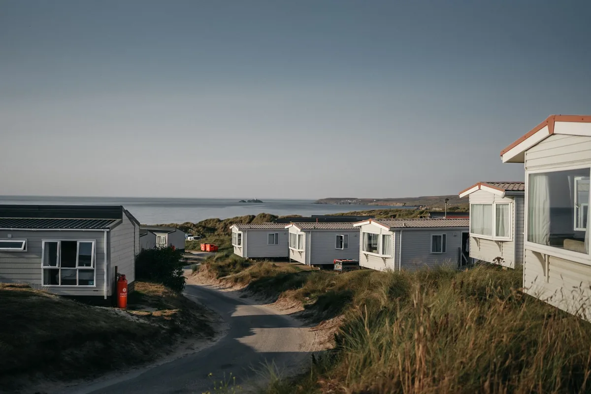 Tranquil seaside view of static caravans by the coast during summer.