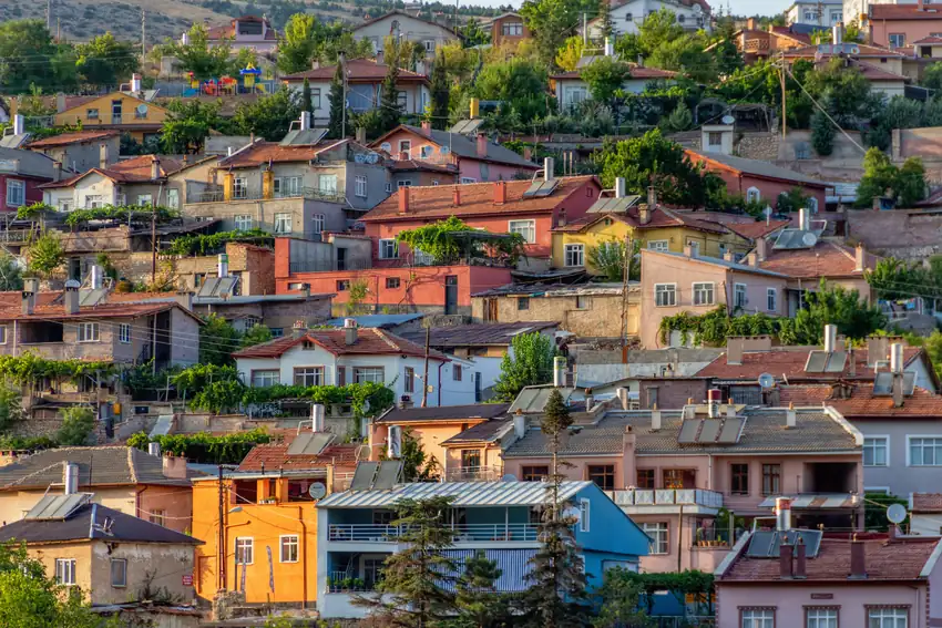 Vibrant hillside view of colorful homes clustered closely in a Turkish town.