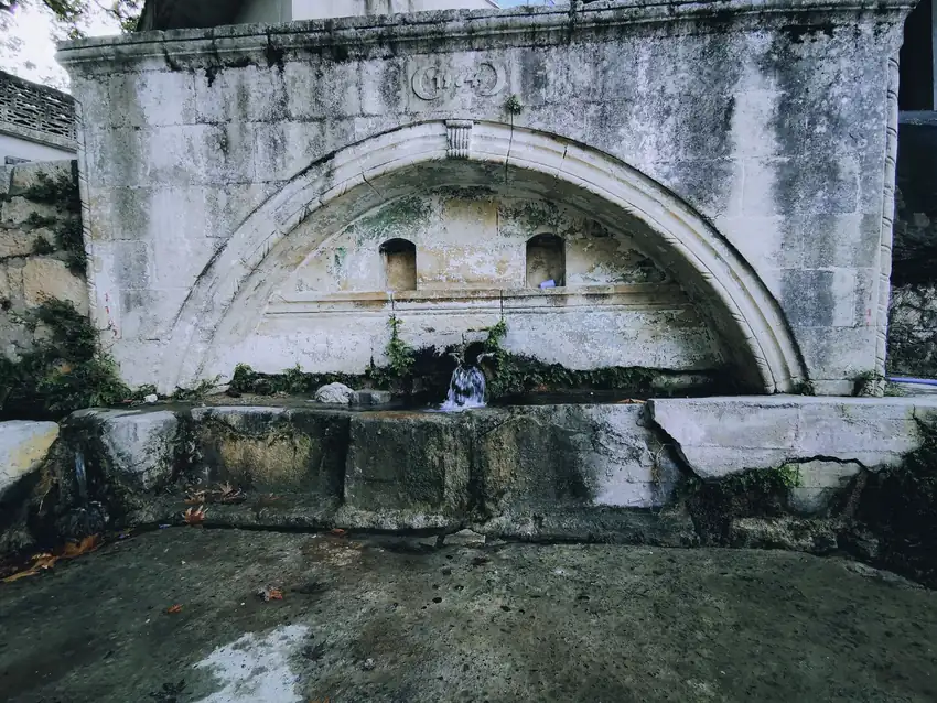 A serene image of an ancient stone grotto featuring a gentle water flow, capturing rustic beauty.